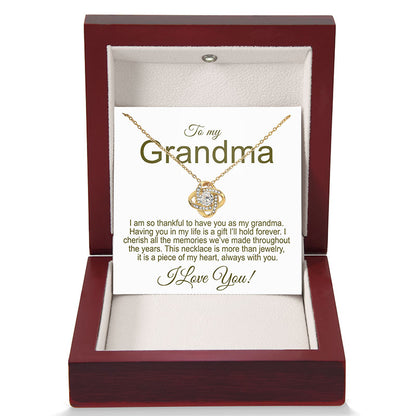 Gold necklace in a jewelry box with a card for a grandma