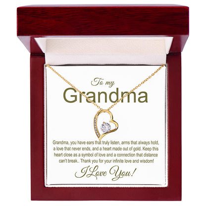 Gold necklace with heart design in a gift box addressed to 'Grandma' with a sentimental message.