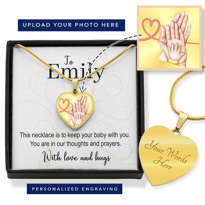 Gold heart-shaped necklace with engraved hands and personalized message card