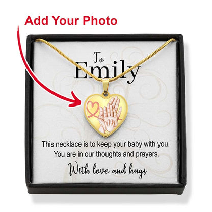 Gold heart-shaped necklace with baby hands design in a gift box, personalized for infant loss.