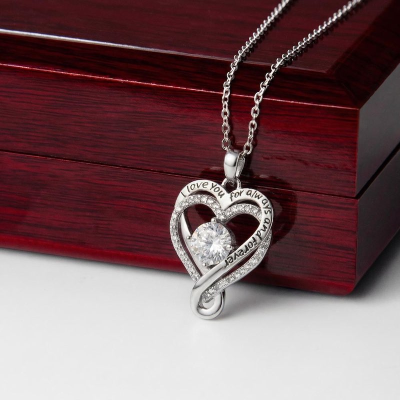 Silver heart-shaped pendant necklace with a centered cubic zirconia on a wooden gift box