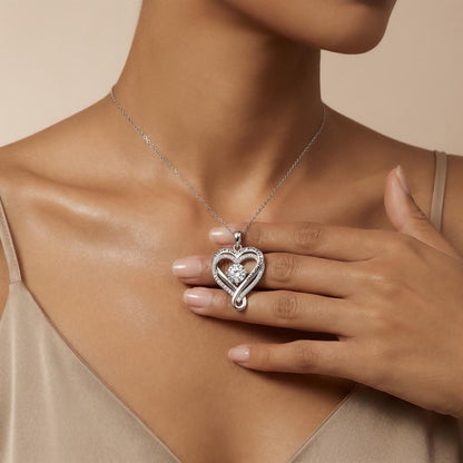 Heart-shaped necklace with a centered cubic zirconia stone on pendant worn by a model.