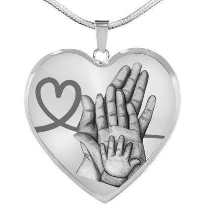 Heart-shaped pendant with hands and a heart design on a white background