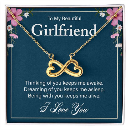 Gold infinity heart necklace on a blue gift card reading “To My Beautiful Girlfriend,” displayed in a gift box.