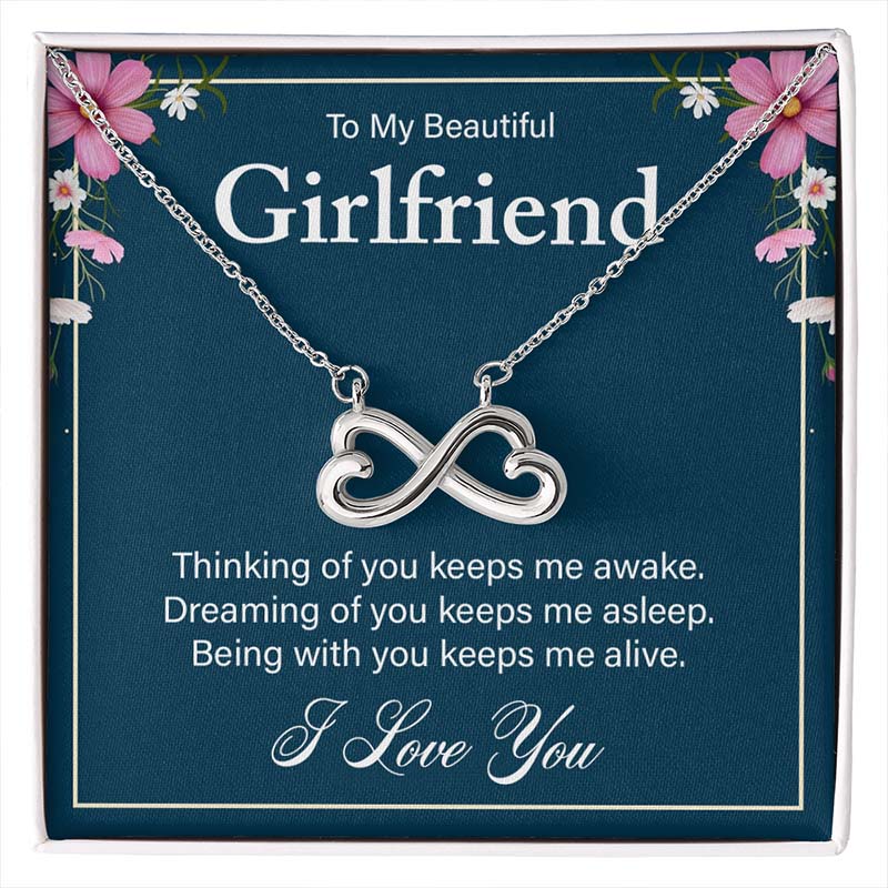 Silver infinity heart necklace on a blue gift card reading “To My Beautiful Girlfriend,” displayed in a gift box.