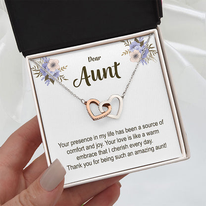 Necklace with interlocking hearts on a card addressed to 'Aunt' held by a hand, gift for aunt from nephew.
