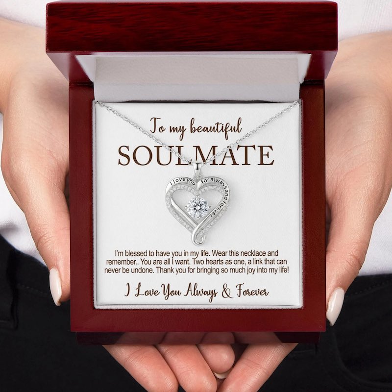 Heart-shaped diamond necklace in a wooden box with the card message: 'To my beautiful soulmate, I love you for always and forever,' held by a hand