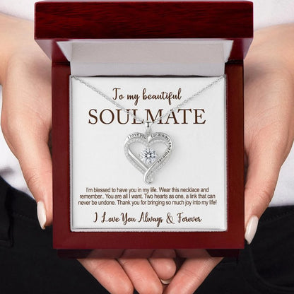Heart-shaped diamond necklace in a wooden box with the card message: 'To my beautiful soulmate, I love you for always and forever,' held by a hand