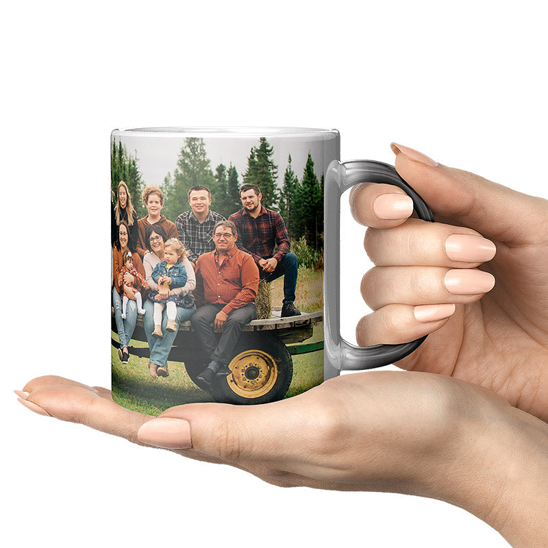 custom print coffee mug: person holding a custom mug with a printed family photo on a white background.