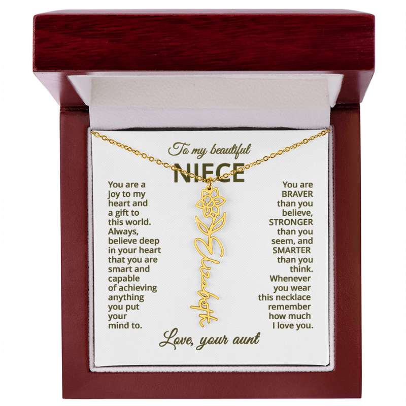 Gold necklace with daffodil flower design with engraved message on a white card for niece in a wooden box