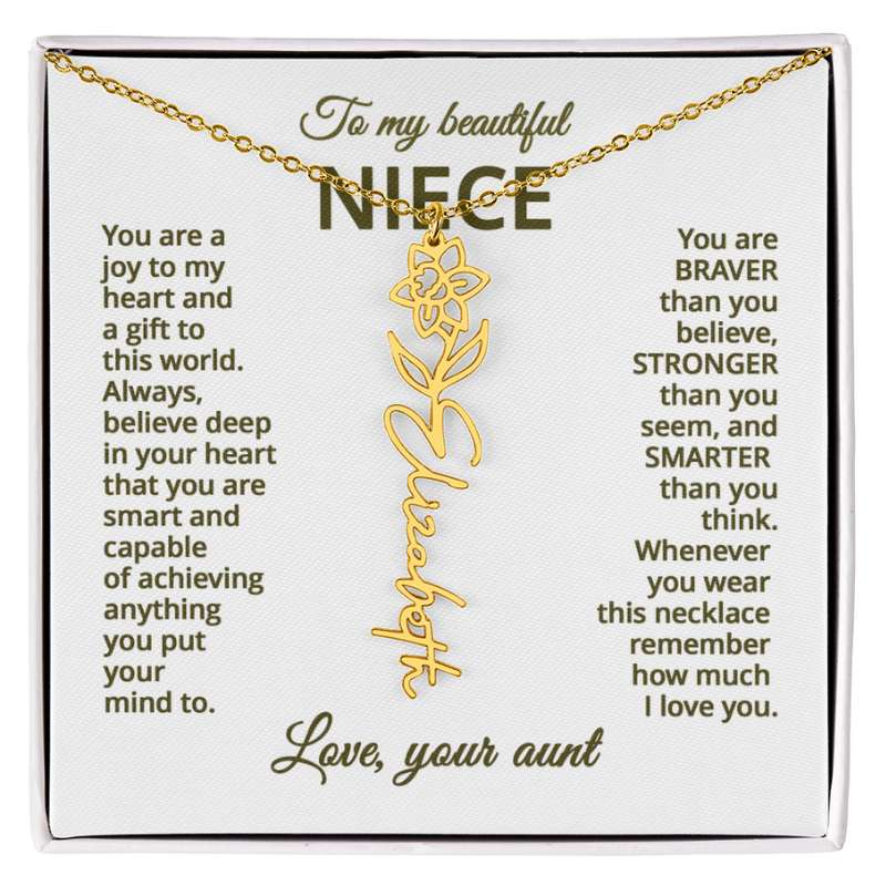 Gold necklace with daffodil flower design with engraved message on a white card for niece.