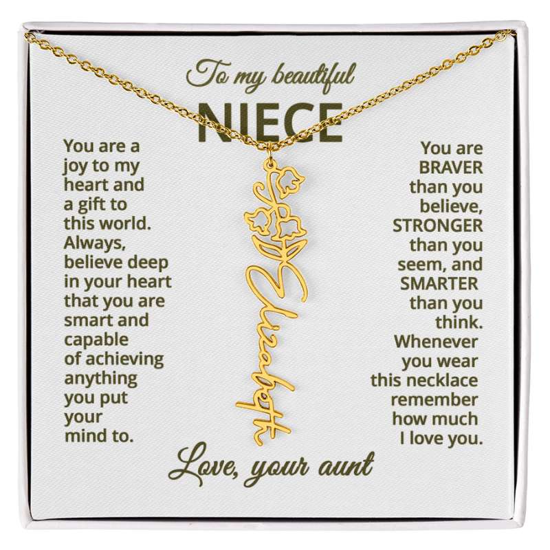 Gold name necklace and lily of the valley flower pendant with a sentimental message card for a niece on a white background.