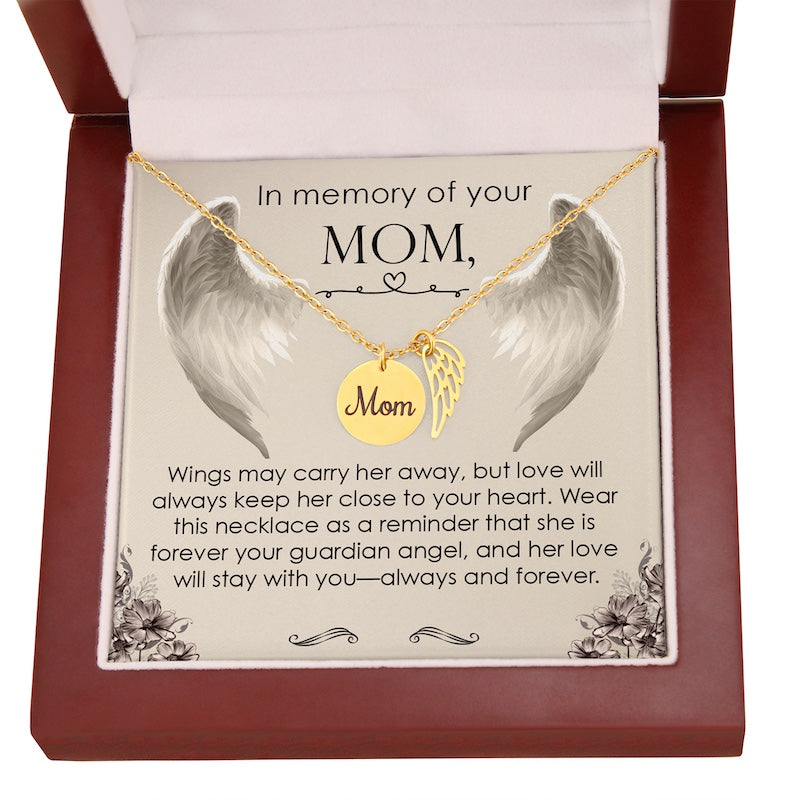 Necklace with angel wings and 'Mom' pendant on a card in a wooden box.