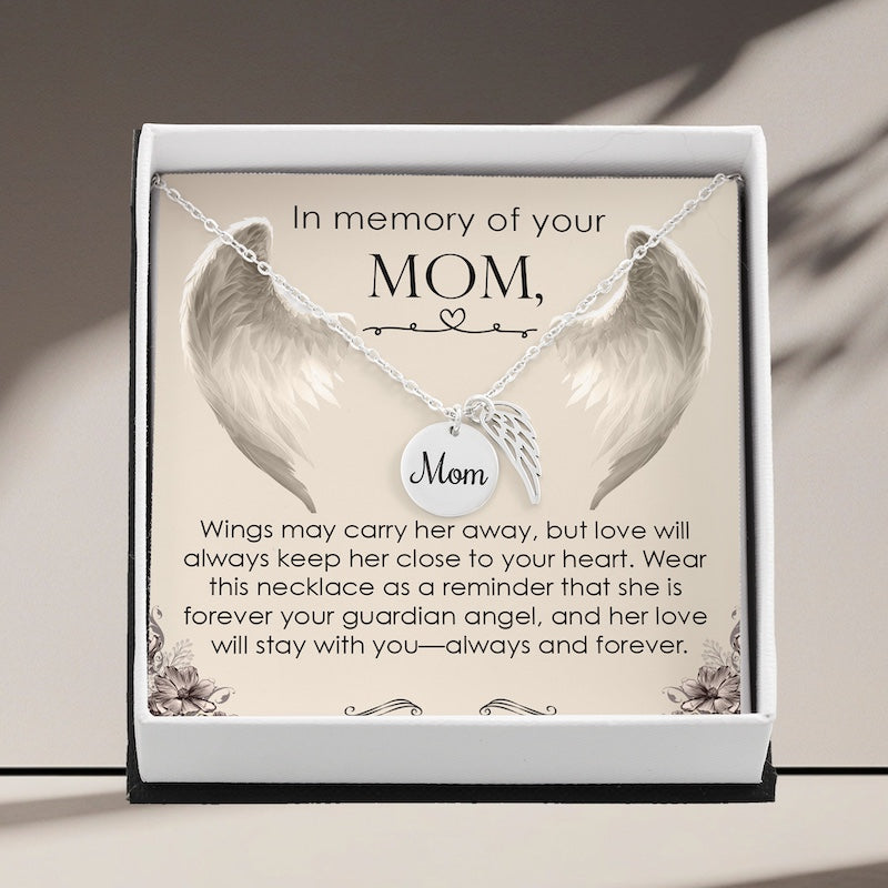 Necklace with angel wings and 'Mom' charm in a decorative box with sentimental text.