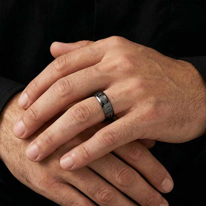 Personalized black men's ring with custom text engraving worn on model's hand