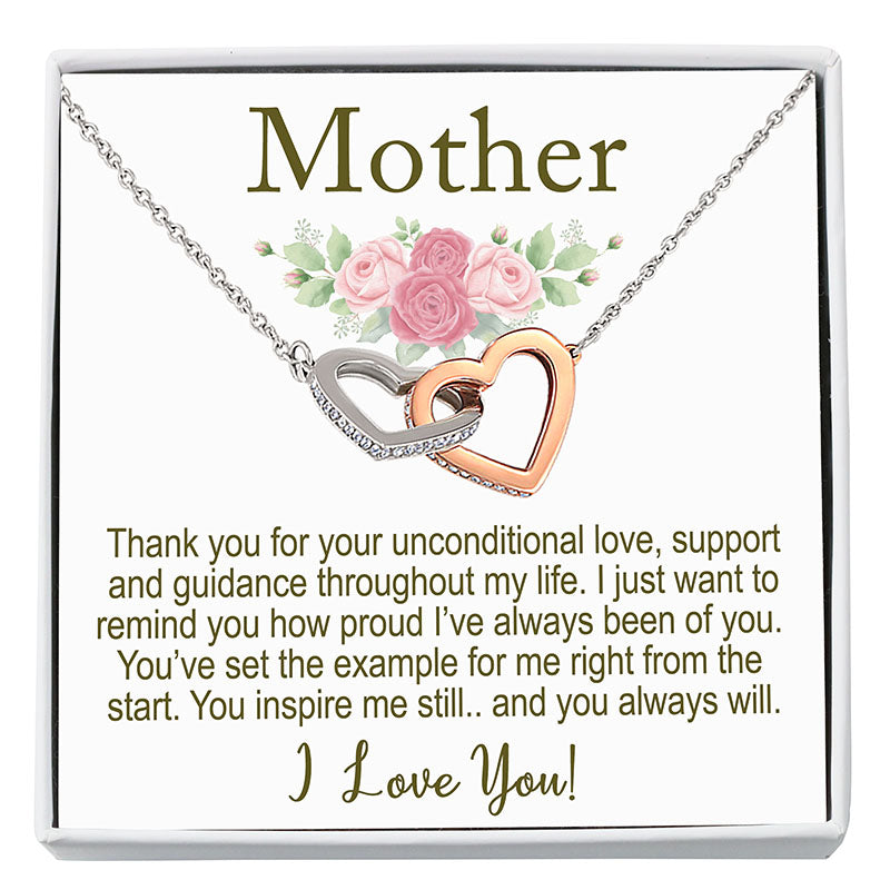 Necklace with interlocking hearts on a card with floral design and text, displayed in a white frame.