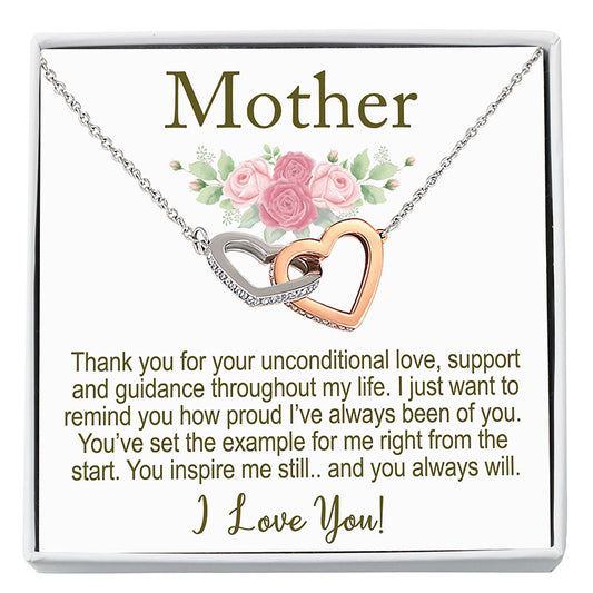 Necklace with interlocking hearts on a card with floral design and text, displayed in a white frame.