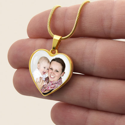custom photo necklace: gold heart-shaped pendant with a photo of a woman and a baby held between fingers
