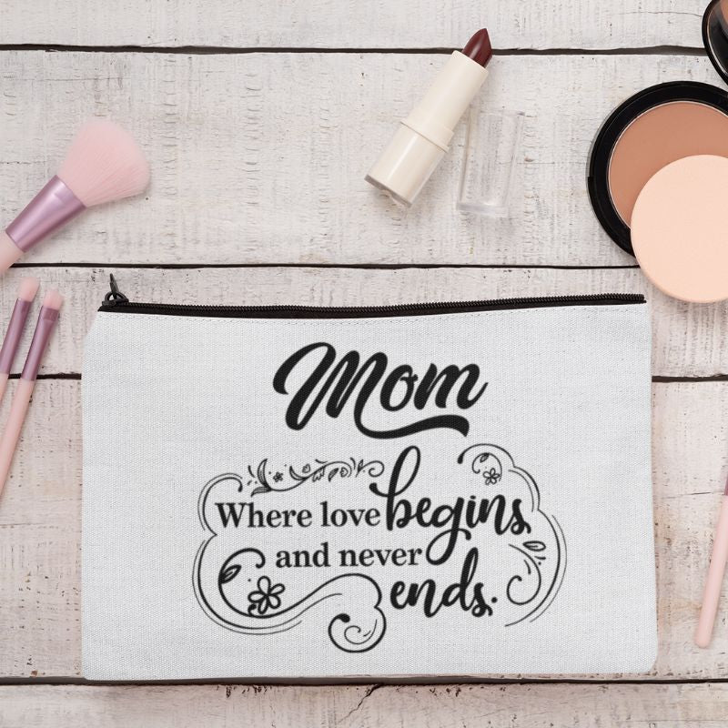 Makeup bag with 'Mom Where love begins and never ends' text on a wooden surface with makeup items.