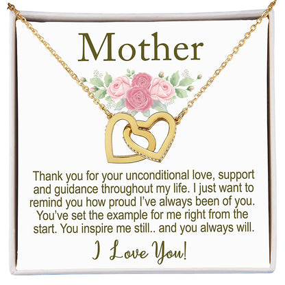 Gold necklace with interlocking hearts on a card with floral design and text.