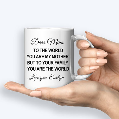 White ceramic mug featuring a heartfelt message for Mom, customized with the name "Evelyn," held by a hand.