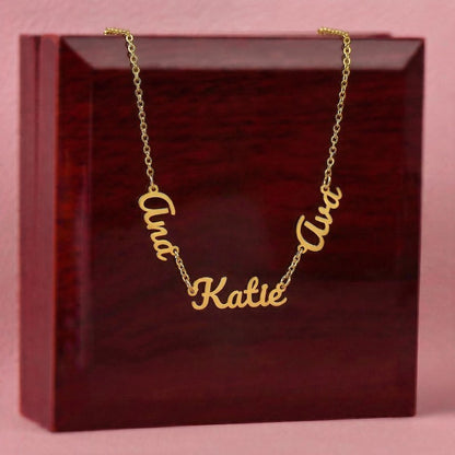 Gold necklace with 'Ana' 'Katie' and 'Ava' cursive pendants on a red box.
