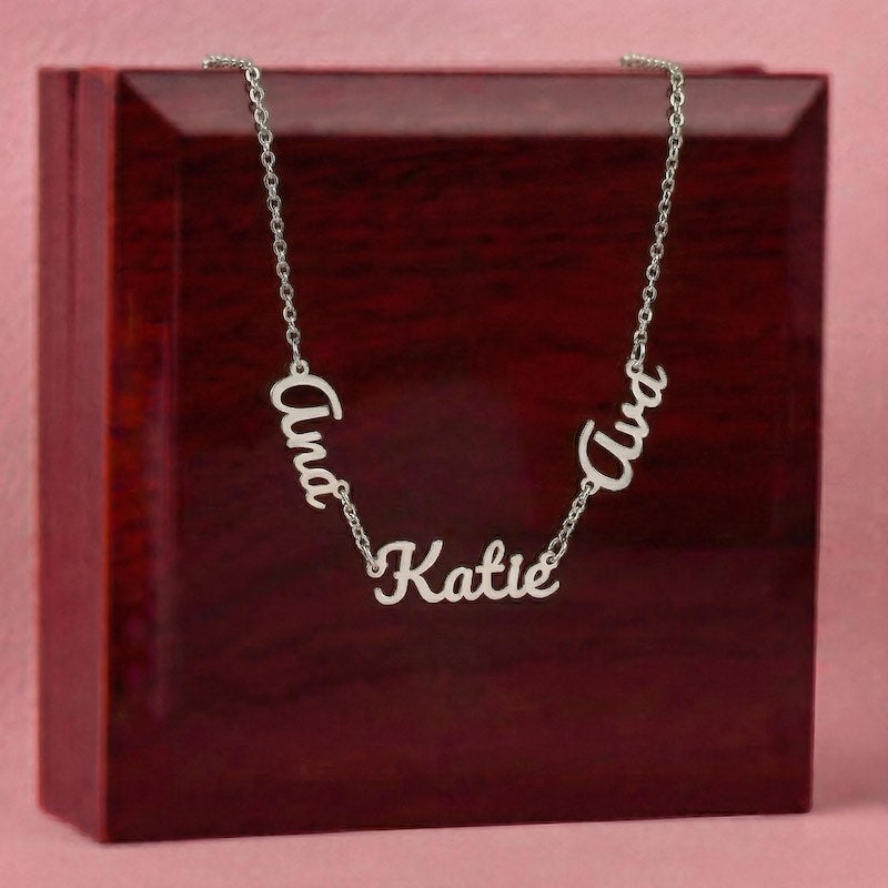 Silver name necklace with 'Ana' 'Katie'  and 'Ava' pendants on a red box with pink background