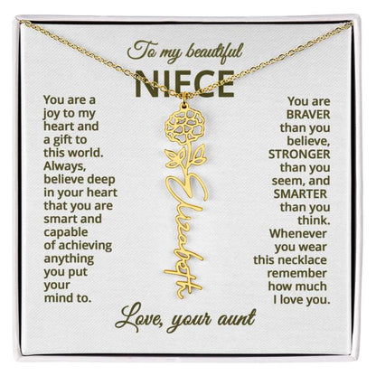 Gold name necklace and marigold flower pendant on a card with sentimental message for niece on a white background 