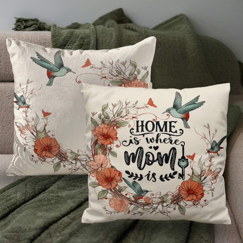Decorative pillows with floral designs and 'Home is where Mom is' text on a couch.