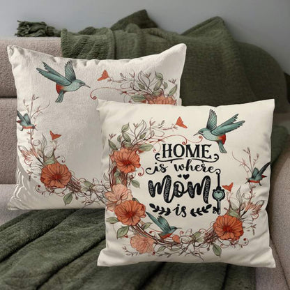 Decorative pillows with floral designs and 'Home is where Mom is' text on a couch.
