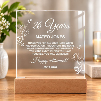 Personalized clear acrylic retirement plaque on a wooden stand with a custom engraved message, set on a sunlit table. - Gifts For Family Online