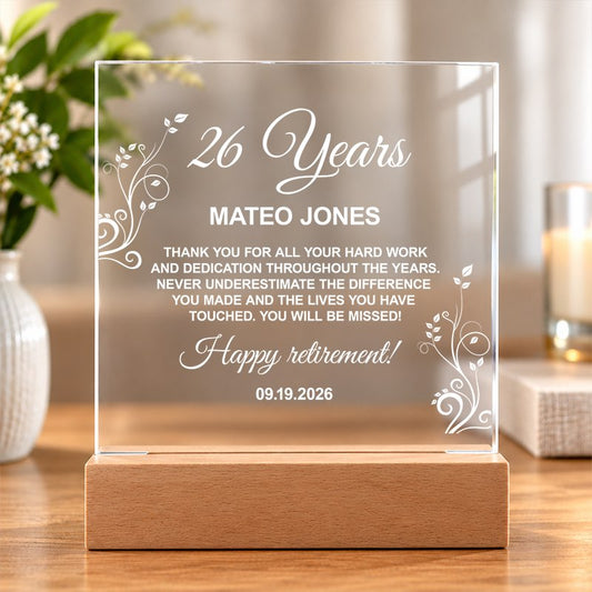 Personalized clear acrylic retirement plaque on a wooden stand with a custom engraved message, set on a sunlit table. - Gifts For Family Online