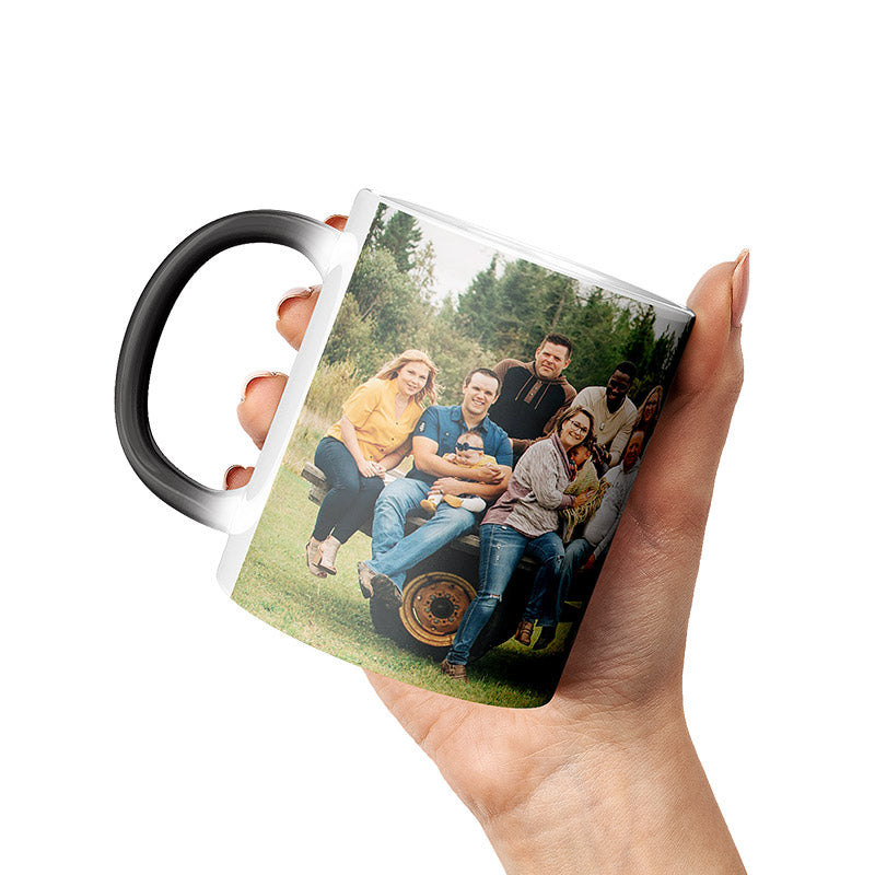 personalized magic coffee mug with a printed photo of a group of family members outdoors, hold by a hand.