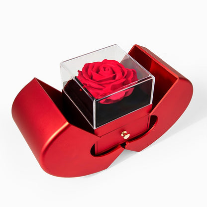 Red rose in a transparent box inside a red heart-shaped box on a white background