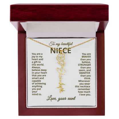 Gold name necklace and morning glory flower pendant on a card with sentimental message for niece on a hite background in a wooden box
