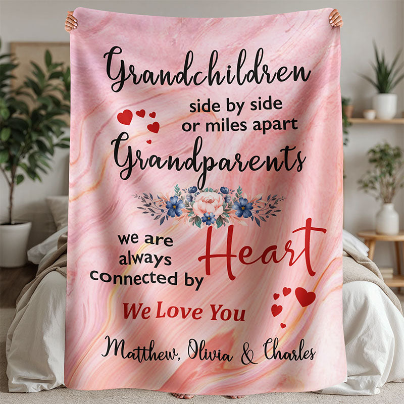 Pink marble-patterned blanket with text about grandparents and floral design, held by a person in a bedroom.