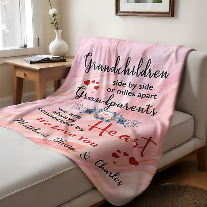 Pink blanket with a heartfelt text for grandparents from grandchildren, laid on a couch in a cozy living room.