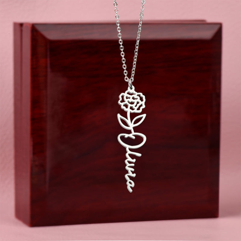 Silver name necklace with a January carnation pendant on a dark red box
