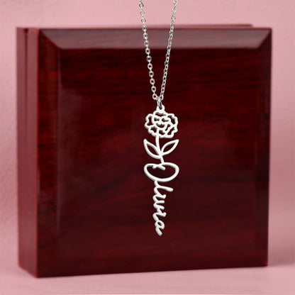 Silver name necklace with a January carnation pendant on a dark red box