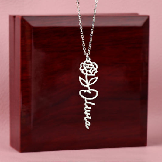 Silver name necklace with a January carnation pendant on a dark red box