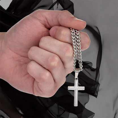 Hand holding a silver chain with a cross pendant against a dark background