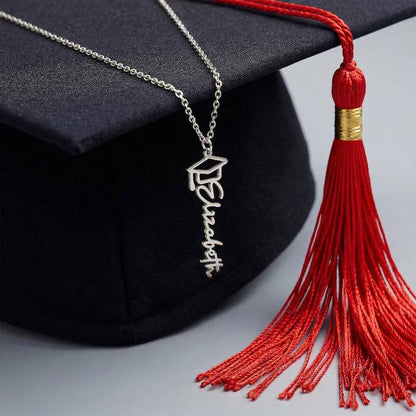 Graduation cap with a necklace and red tassel on a gray background