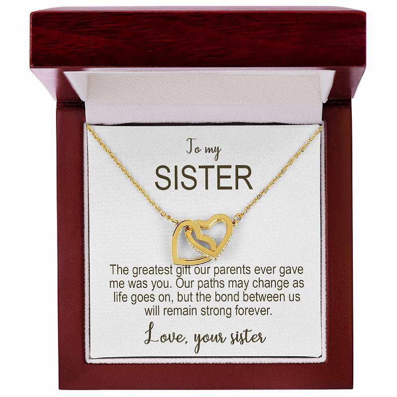 Gold necklace with interlocking hearts in a wooden box with a message card.