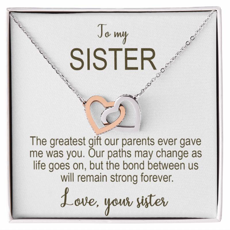 Necklace with interlocking heart pendants on a card addressed to 'my sister' with sentimental text.