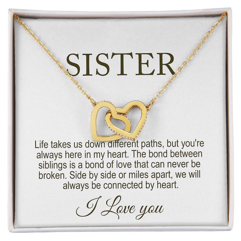 Gold necklace with interlocking hearts on a card that reads 'Sister' and sentimental message.