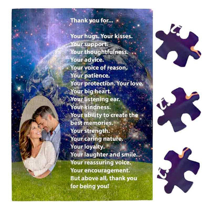 A personalized jigsaw puzzle featuring a custom photo cutout of a smiling couple inside an oval frame on a starry Earth and space background, accompanied by a heartfelt "Thank you for..." message in white text and three loose puzzle pieces on the right.