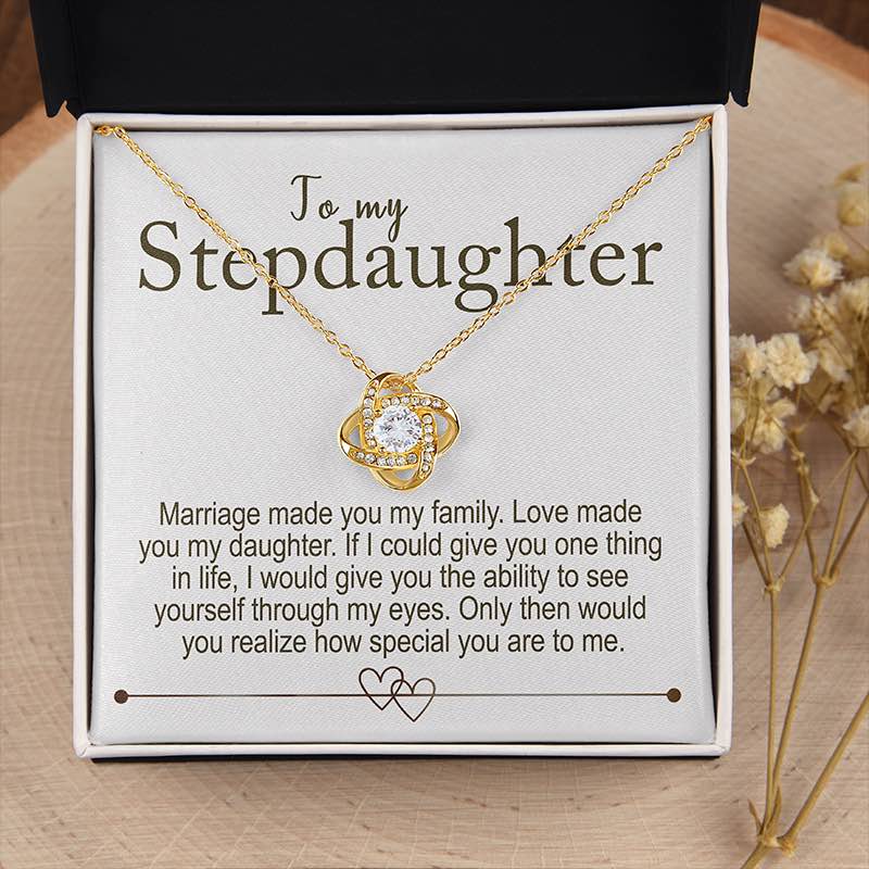 Gold necklace with a message card for stepdaughter on a wooden surface