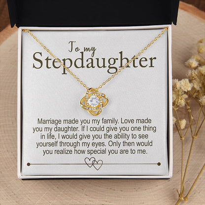 Gold necklace with a message card for stepdaughter on a wooden surface
