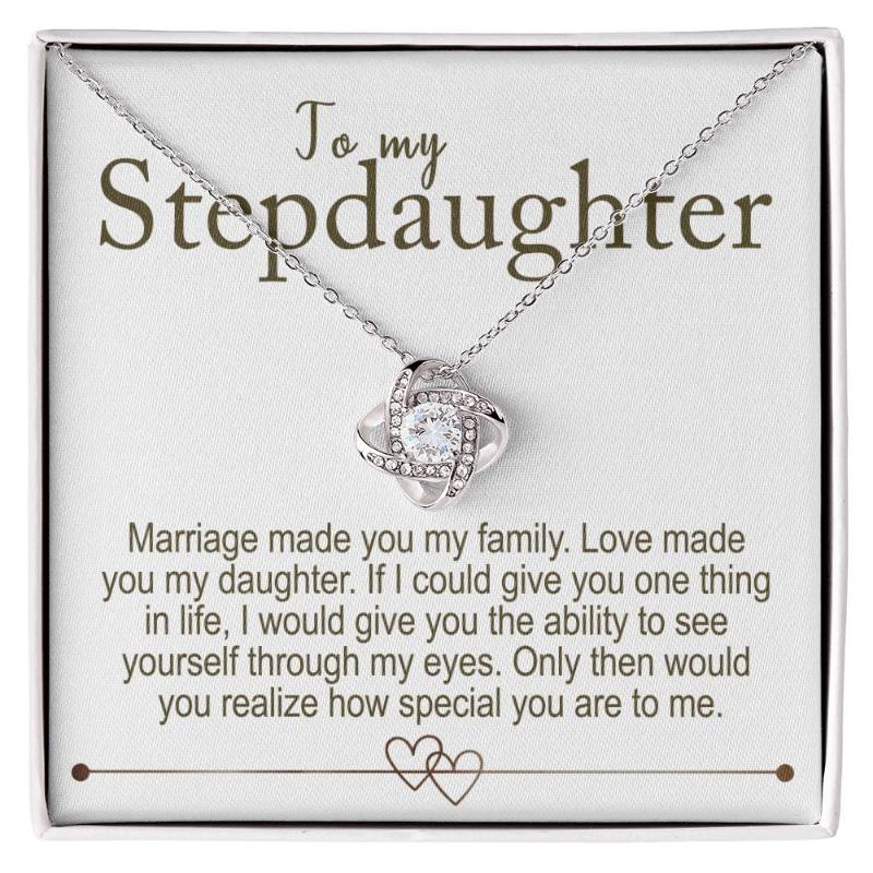 A necklace with a love knot design and cubic zirconia, presented in a box with a personalized message card to a stepdaughter.