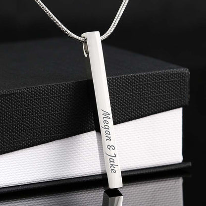 Silver bar pendant with engraved names on a black and white box background